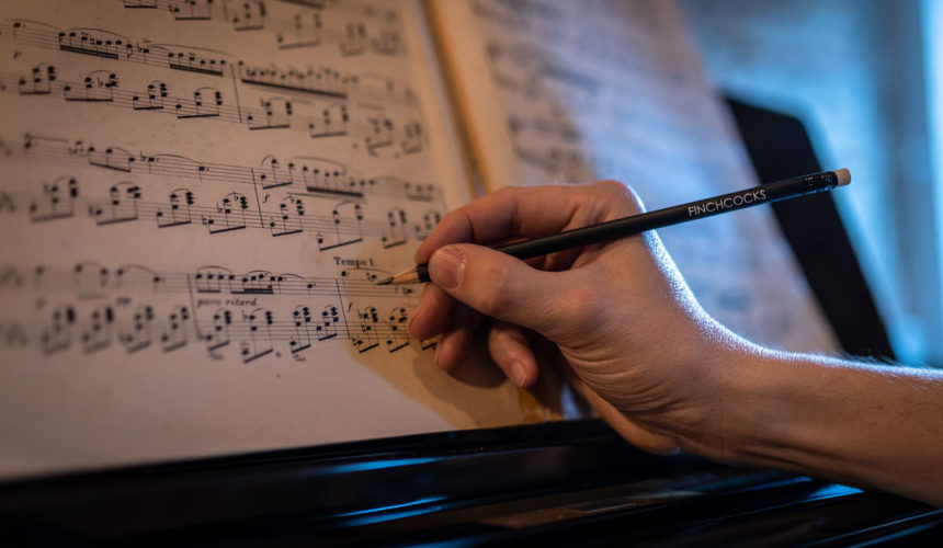 Copy of sheet music being annotaed in pencil