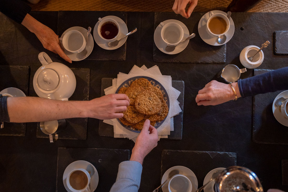Hands reaching for biscuits at coffee table