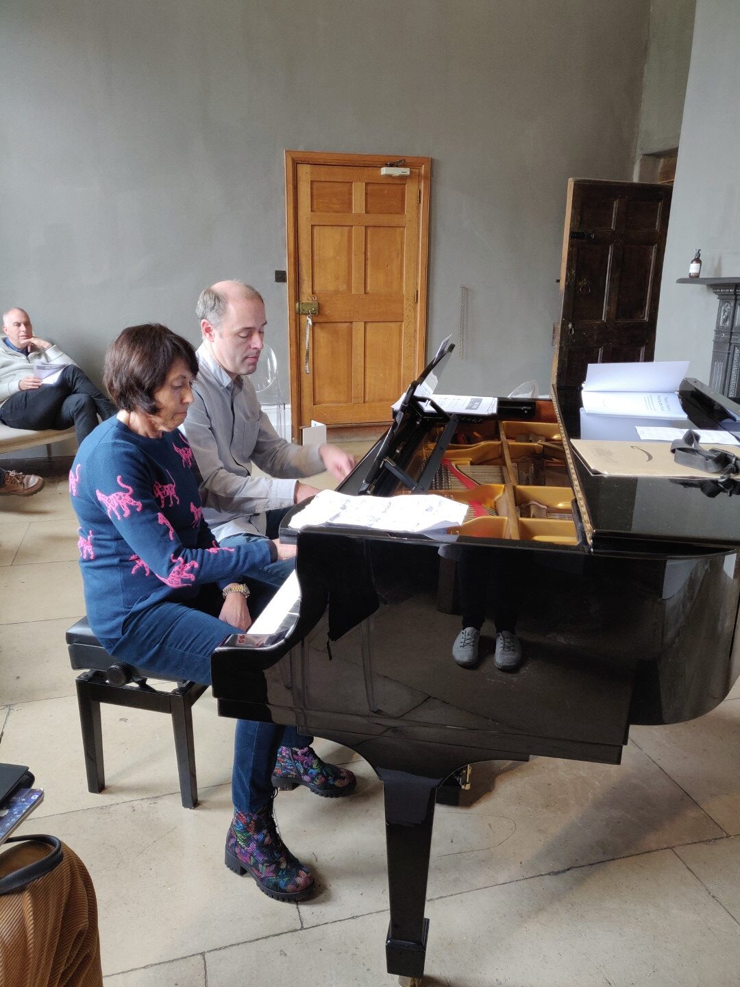 Woman and man playing duet at Steinway in workshop