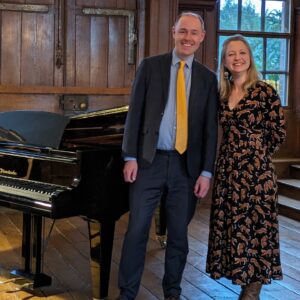 David Hall and Jennifer Maslin stand in Finchcocks main hall front right of the Bosendorfer smiling