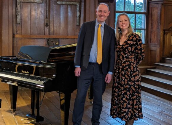 David Hall and Jennifer Maslin stand in Finchcocks main hall front right of the Bosendorfer smiling